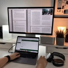 a person sitting at a desk with a laptop and headphones in front of them