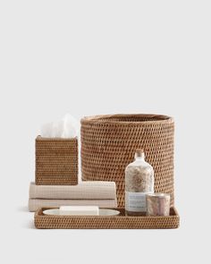 an assortment of bathroom items including soap, toiletries and towels in wicker baskets