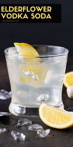 the elderflower vodka soda is served in a glass with ice and lemon wedges