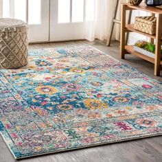 a colorful rug with an ornate design on the floor in front of a door and window