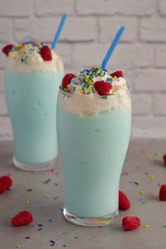 two glasses filled with ice cream and raspberry slushie on top of a table