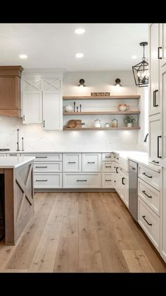 a kitchen with white cabinets and wood floors is pictured in this image from the front view