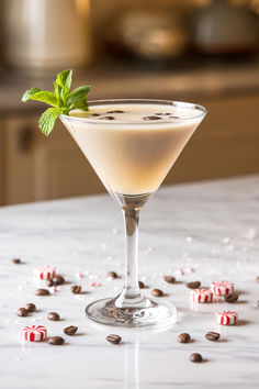 a martini cocktail with mint garnish and candy canes on the counter top