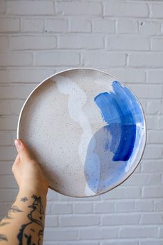 a person holding up a white and blue plate