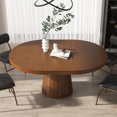 a round wooden table with four chairs around it and a vase on the table next to it