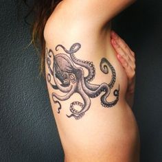 an octopus tattoo on the back of a woman's left arm and lower half