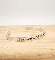 This makes a great gift for anyone!  6 inch by 1/4 inch aluminum cuff bracelet is adjustable, does not tarnish or rust, and is light weight.  This cuff is engraved with the quote, "it is well with my soul" This bracelet can be engraved with any short sayings, words, or names that you would like within 47 characters including spaces.  I love customs orders! If you would like this bracelet engraved with a different saying or names, please let me know. I would be happy to work with you to create that perfect gift! Short Sayings, Scripture Jewelry, It Is Well With My Soul, Design Stamps, It Is Well, Inspirational Quote, Bracelet Gift, Gift For Mom, Cuff Bracelet