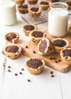 mini chocolate chip pies on a cutting board next to a glass of milk and some cookies