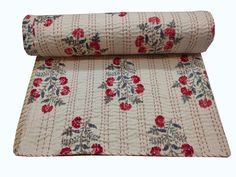 a rolled up rug with red flowers on it