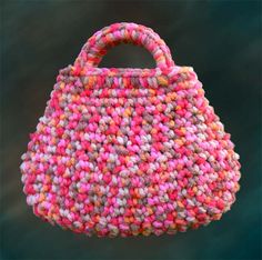 a pink and orange handbag hanging from a hook