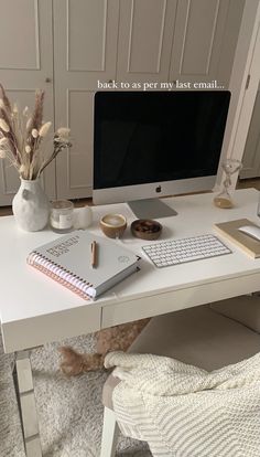 a desk with a computer, keyboard and mouse on it in front of a white wall