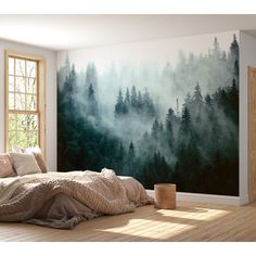 a bedroom with a forest mural on the wall