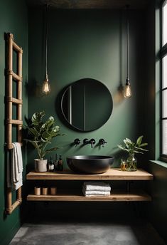 a bathroom with green walls and a round mirror on the wall, along with plants