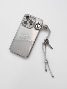 an iphone case with a lanyard attached to it on a white surface and a keychain hanging from the back