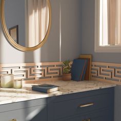 a bathroom with marble counter tops and blue cabinets, along with a round mirror above the sink