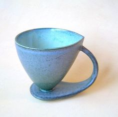 a blue cup sitting on top of a white table