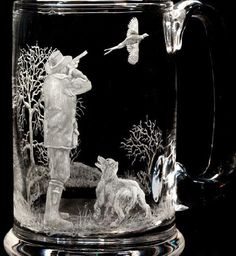 an etched glass mug with a man and two dogs