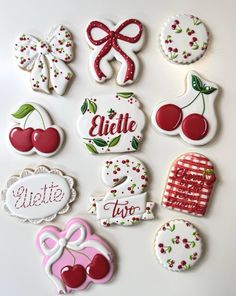 decorated cookies are arranged in the shape of letters, numbers and bows on a white surface