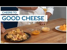 a person pouring cheese onto some food on a wooden table with the words cheers to good cheese