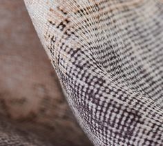 an up close shot of the fabric on a chair with brown and white checkered pattern