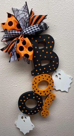 halloween decorations are hanging on the wall with black, orange and white polka doted letters