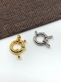 two gold and silver rings sitting on top of a white surface