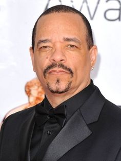 a man in a tuxedo and bow tie posing for the camera at an awards event