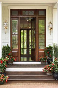 the front door is decorated with potted flowers