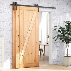 an open sliding door in a living room with white brick wall and wooden flooring