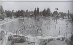 an old black and white photo of people playing in the water at a public park