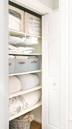 an organized closet with linens and baskets