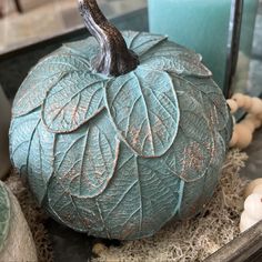 a decorative blue pumpkin sitting on top of a table