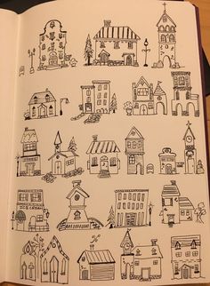 an open book with drawings of houses on it