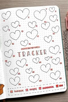 an open notebook with hearts and the words tracker on it