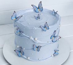 a white cake with blue butterflies on it