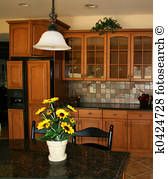 a vase with yellow flowers sitting on top of a kitchen counter next to a sink