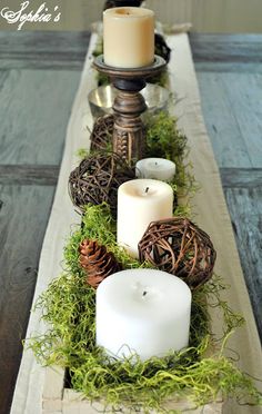 a table with candles and moss on it