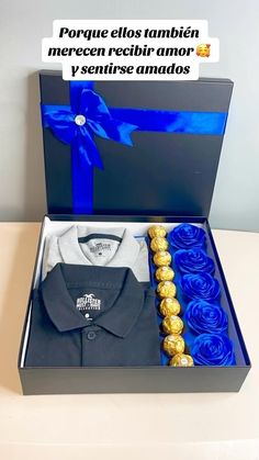 an open box with some blue roses and a shirt in it that says porque els tanbien merecin recibir amo y sentirer amados