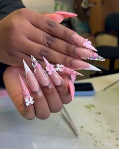 a woman's hand with pink and white stiled nail designs on her nails