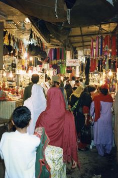 a group of people standing in front of a store filled with lots of items on display