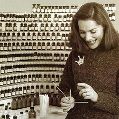 a woman standing in front of a counter with bottles on the wall and holding a toothpick