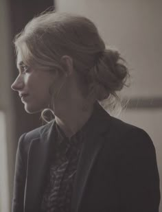 a woman in a suit and tie looking off to the side