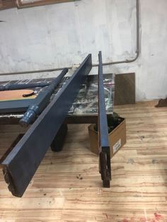 a table that is sitting on top of a wooden floor with a guitar in the background