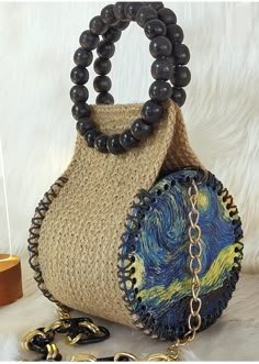 a purse with a chain around it sitting on top of a white furnishing