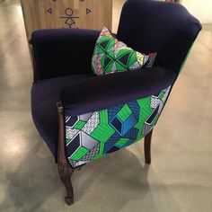 a blue chair with colorful pillows on it in a room filled with other furniture and decor