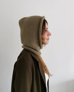 a woman wearing a knitted hoodie and looking off to the side in profile