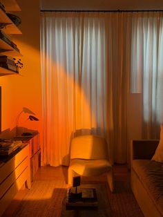 a living room with an orange light coming through the curtains