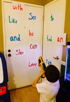 a young boy holding a drillet in front of a door with words written on it