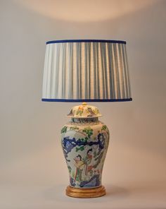 a lamp that is on top of a table with a blue and white lampshade