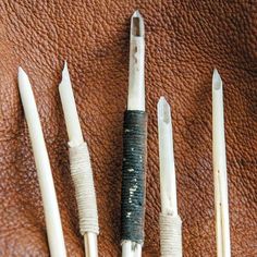 four different types of pens sitting on top of a brown leather surface next to each other